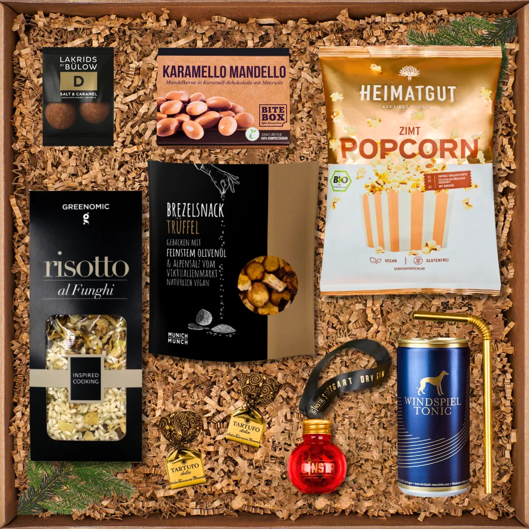 Geschenkbox mit verschiedenen Snacks: Popcorn, Risotto, Karamellmandeln, Trüffel-Brezelsnack, Tonic-Getränk und Pralinen.